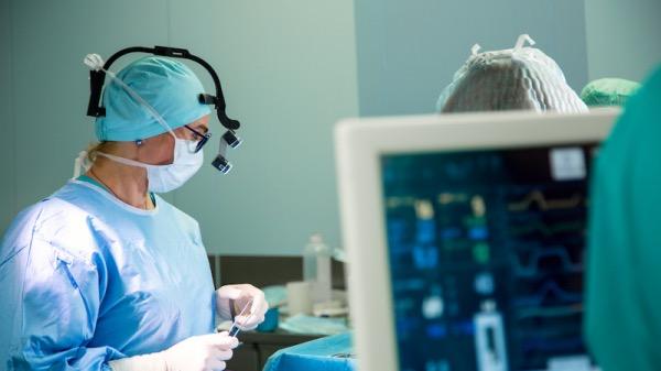 Ärztin mit chirurgischer Lupenbrille im OP